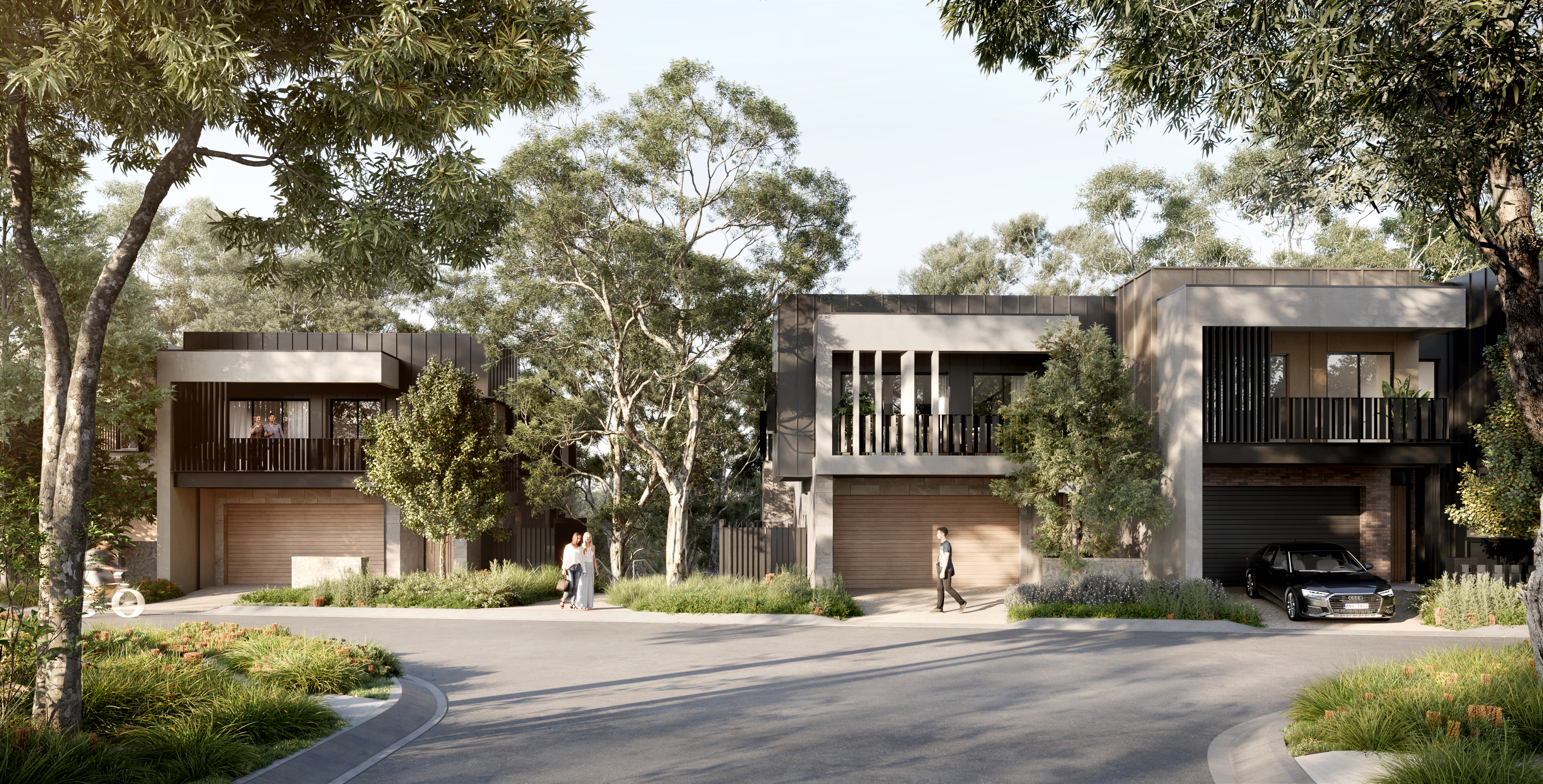 Modern houses with balconies and garages, surrounded by trees and greenery, on a curved road.