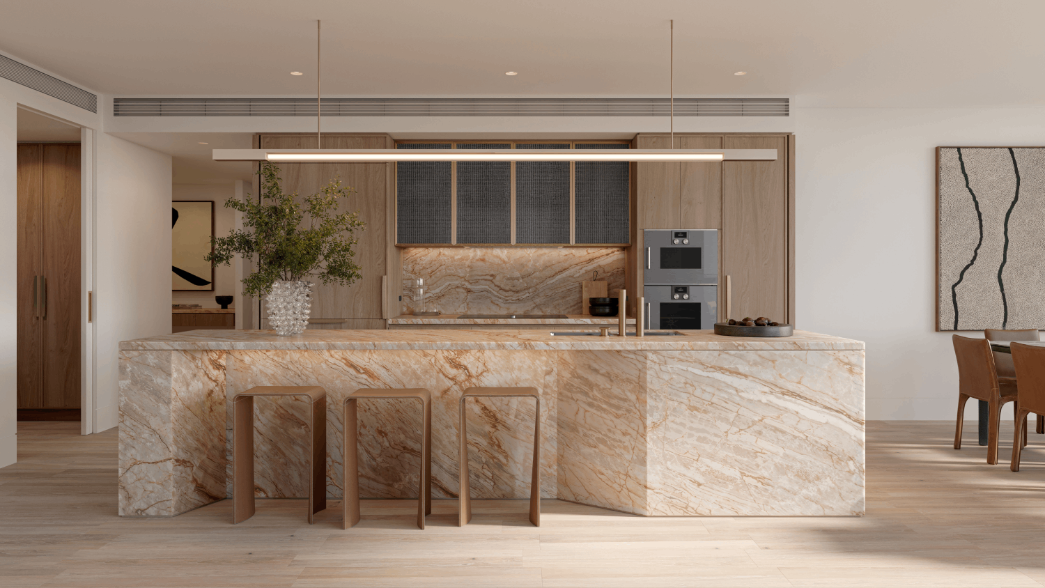 A modern kitchen featuring a large marble island, wooden cabinetry, and stylish bar stools. Natural light enhances the elegant design.