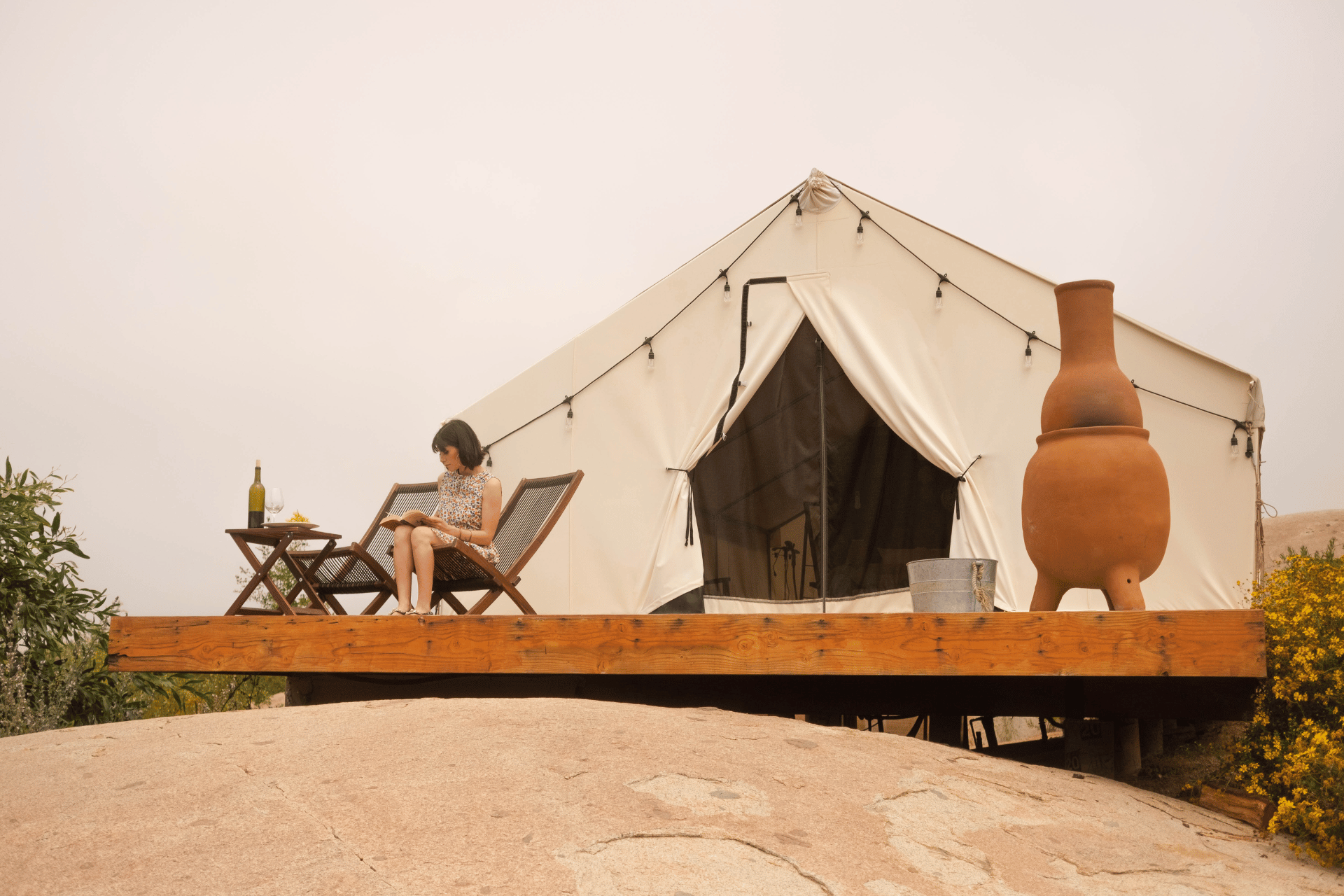 Woman sitting outside glamping tent