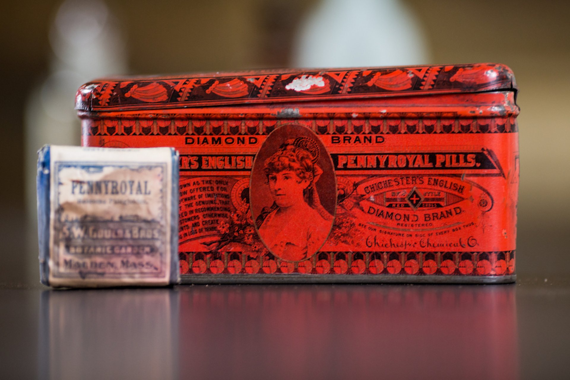 Antique containers of pennyroyal pills and dried herb