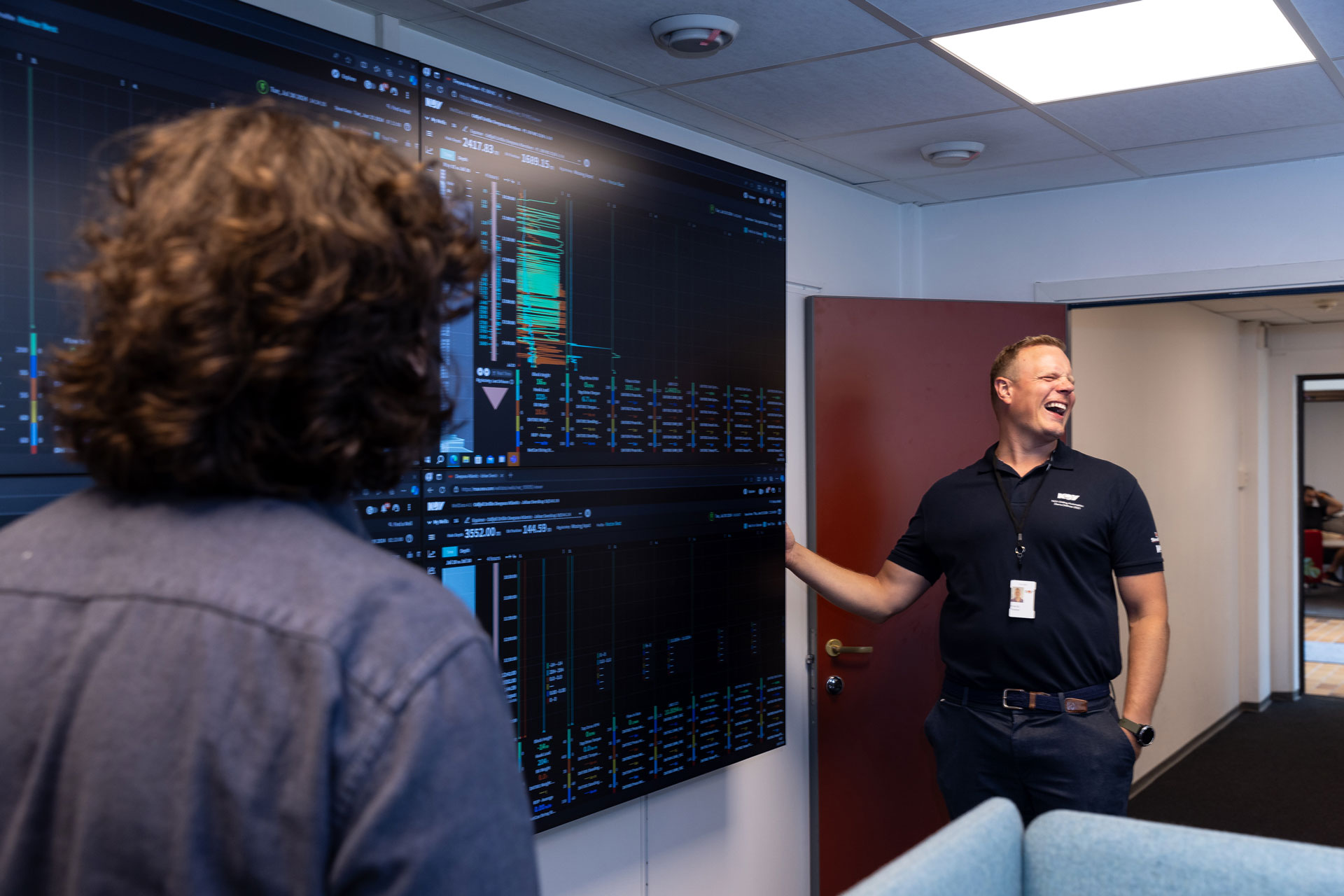 DBS screens showing drilling data, with two employees discussing