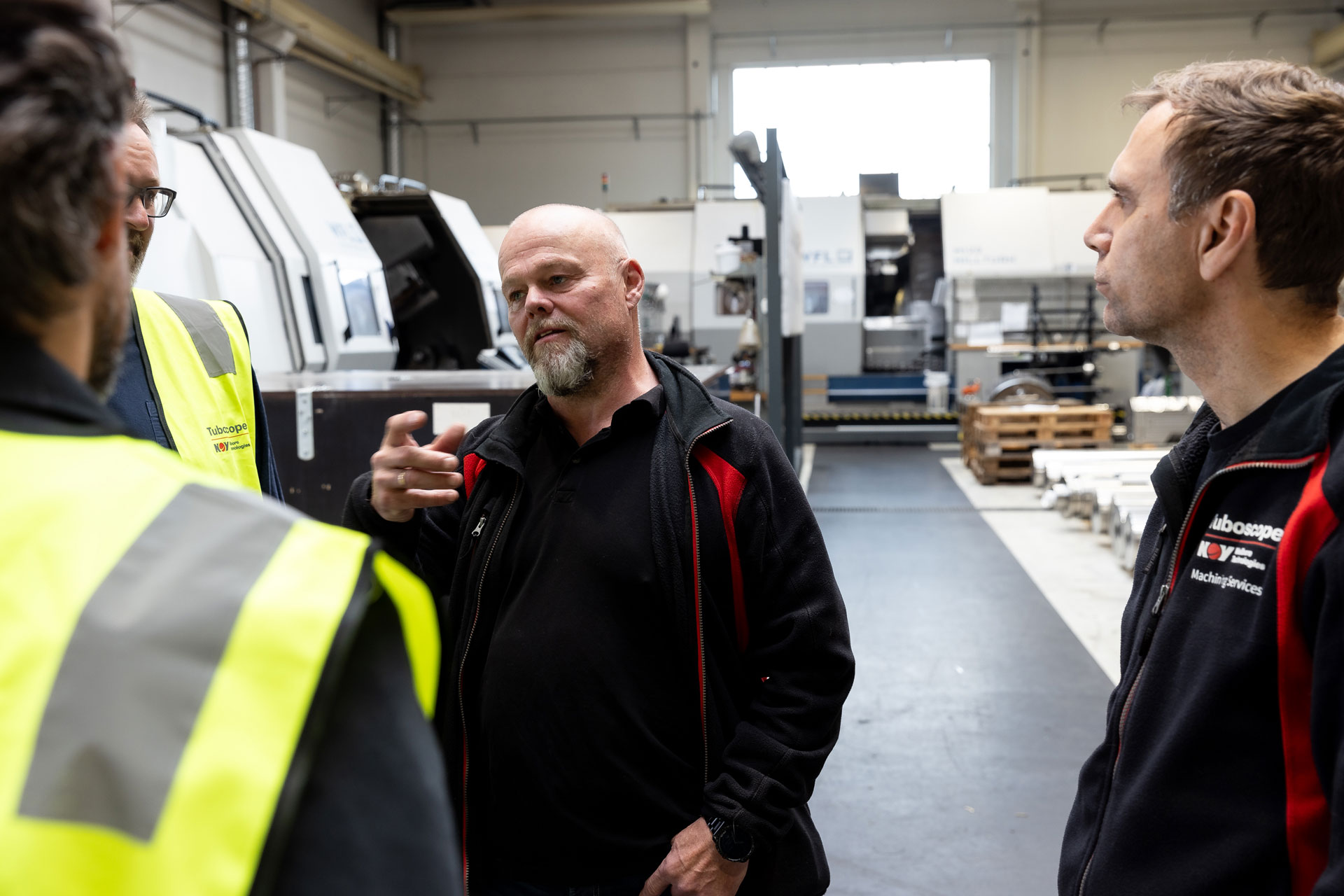 Three employees talking inside the Norway Intelliserv facility