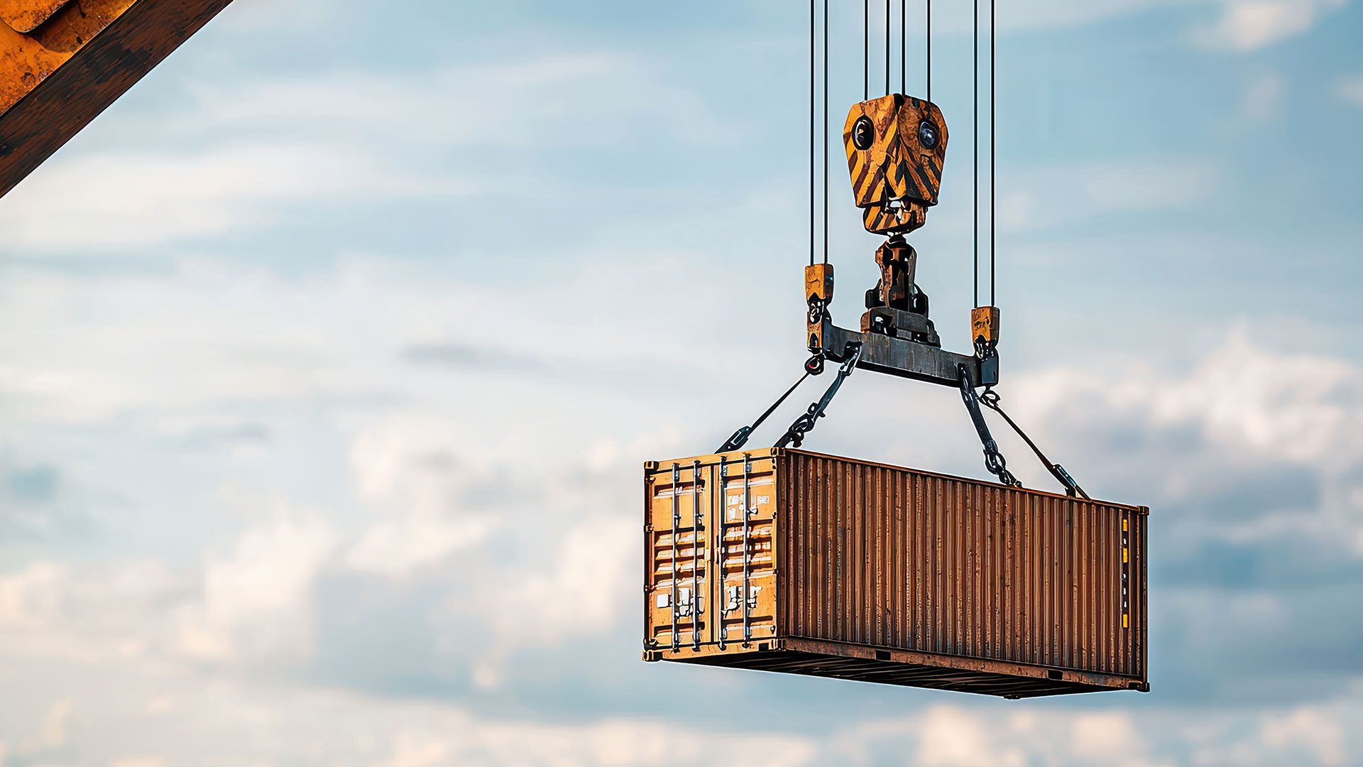 A cargo container is being lifted by a crane