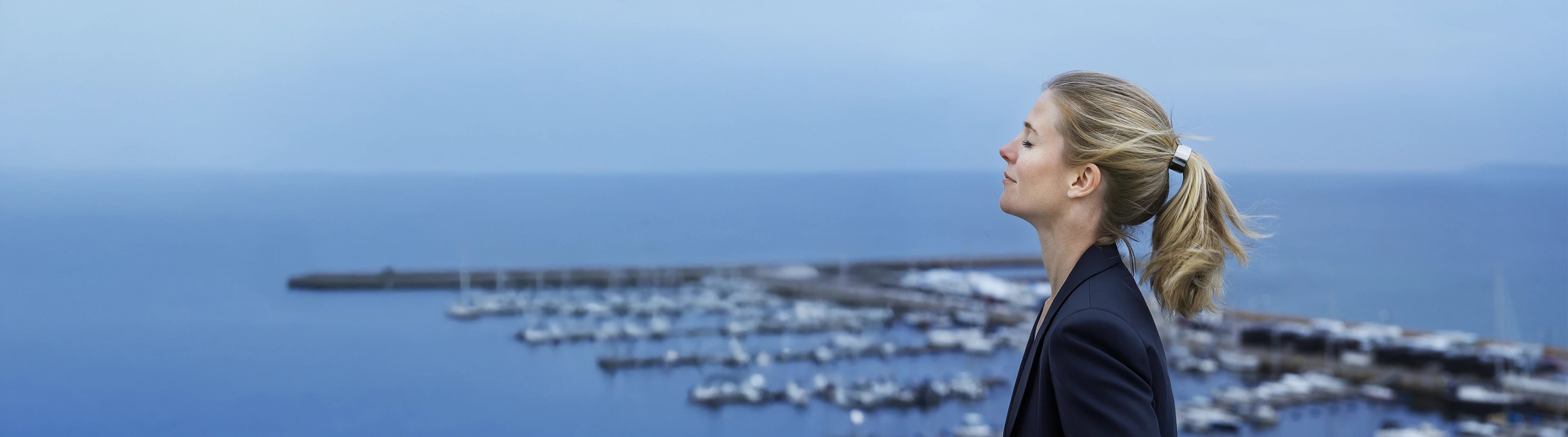 Kvinna andas ren luft vid havet