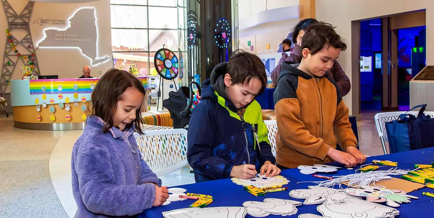 Two young boys and a girl doing craft at NYPA visitors center