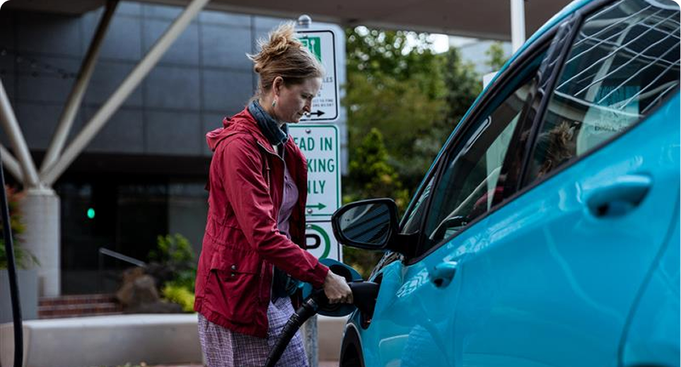 Woman charging electric vehicle