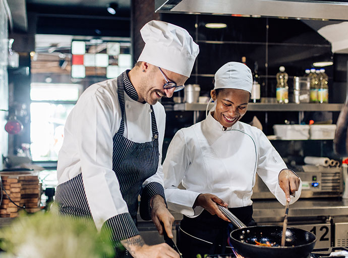 Young cook receiving training from the chef.