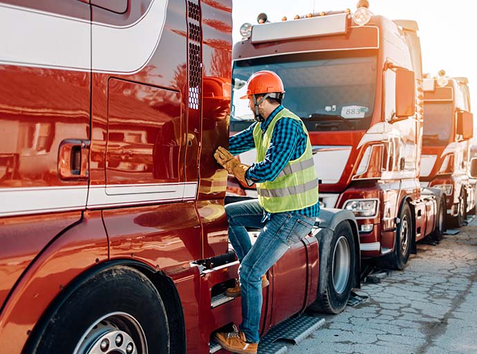Truck driver performing a safety check on his vehicle.