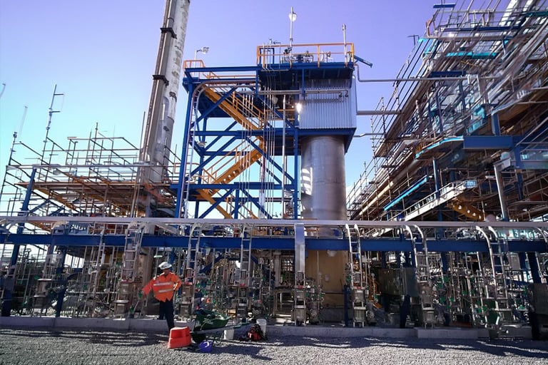 Industrial ammonia processing facility with pipes, tanks, and scaffolding