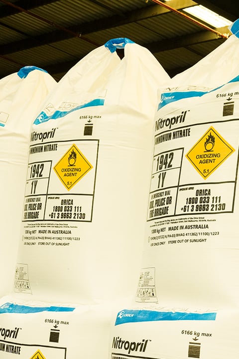 Stacked bulk bags of ammonium nitrate stored in an industrial warehouse