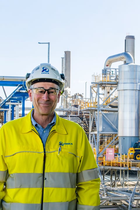 Worker in high-visibility safety gear at an industrial processing facility