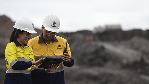 Two engineers using BlastIQ™ Mobile tablet to discuss blast designs