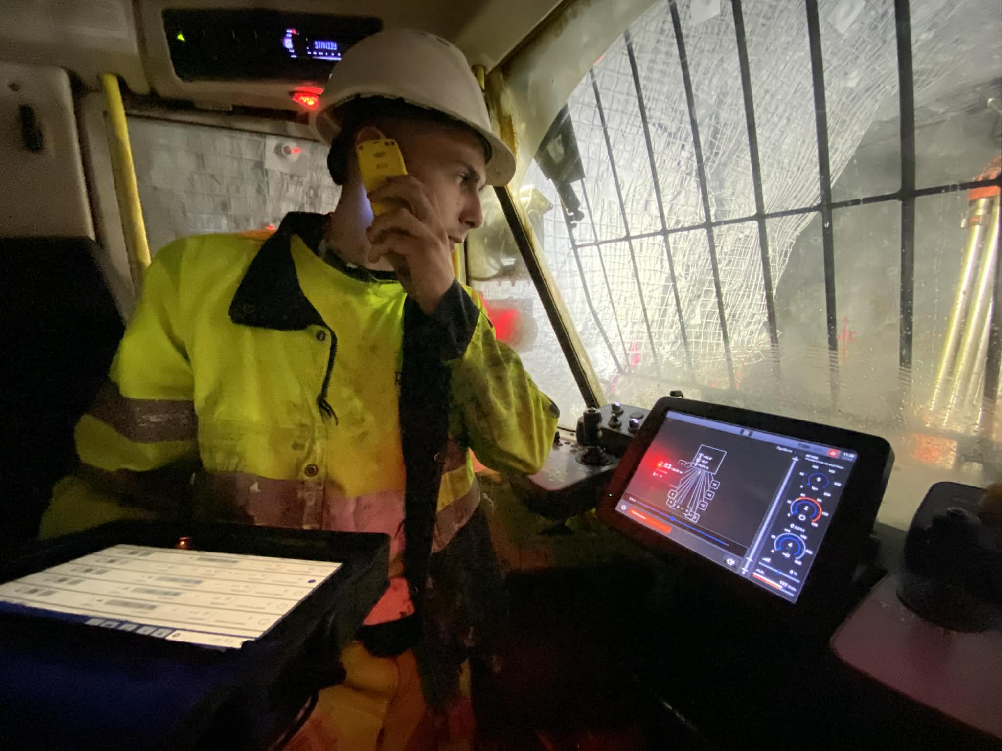 Man on phone using BlastIQ Mobile on a tablet in a production drill rig