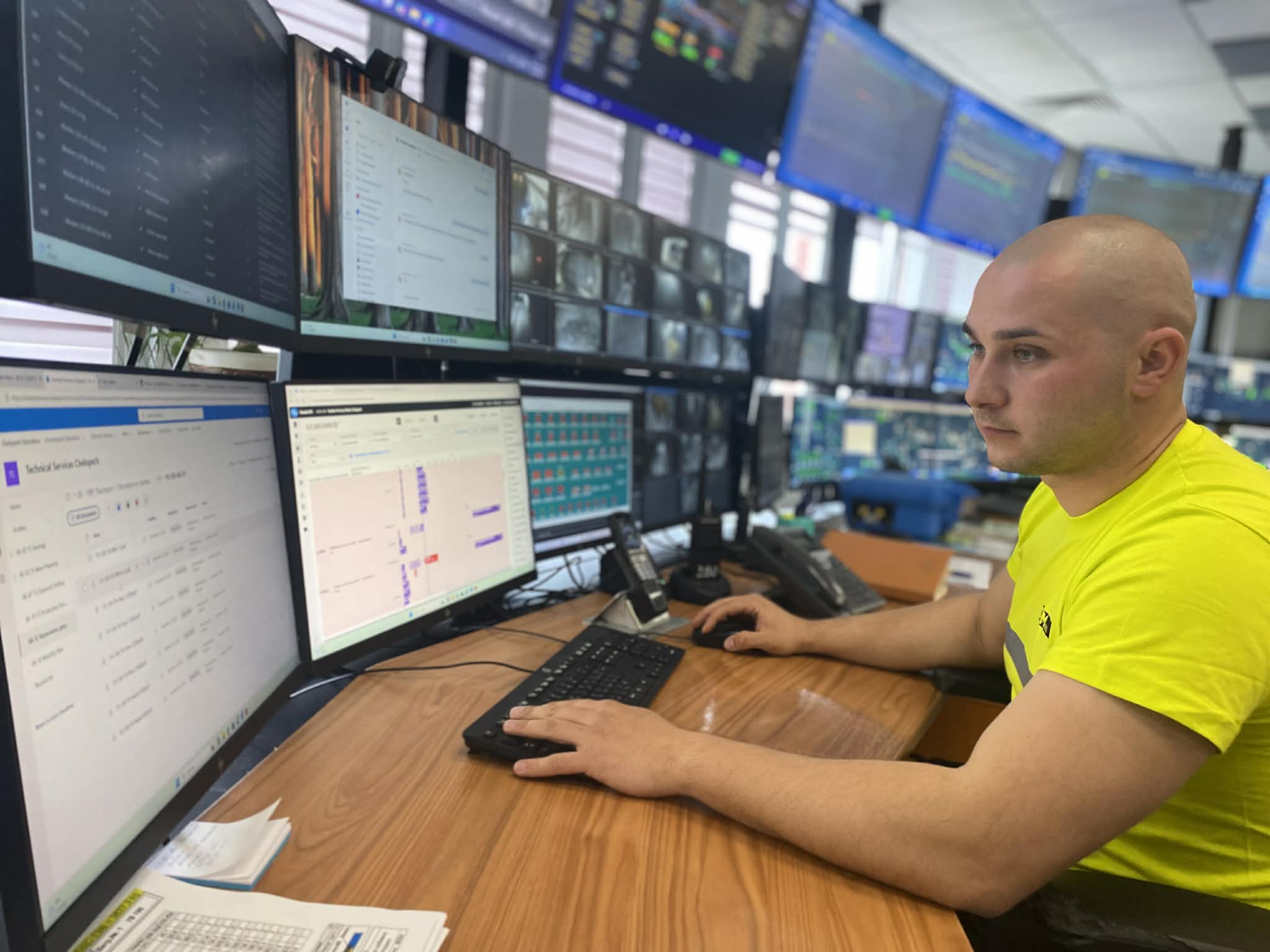 Man looking at data in front of multiple computer screens