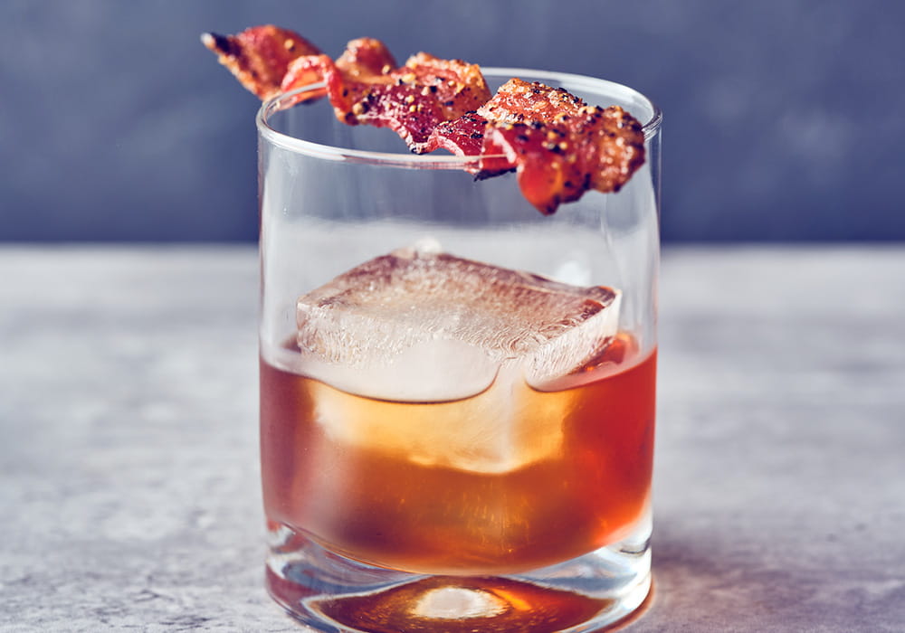 WHISTLEPIG MAPLE OLD FASHIONED WhistlePig PiggyBack bourbon, WhistlePig's own Vermont maple syrup, Angostura bitters and candied peppered bacon.