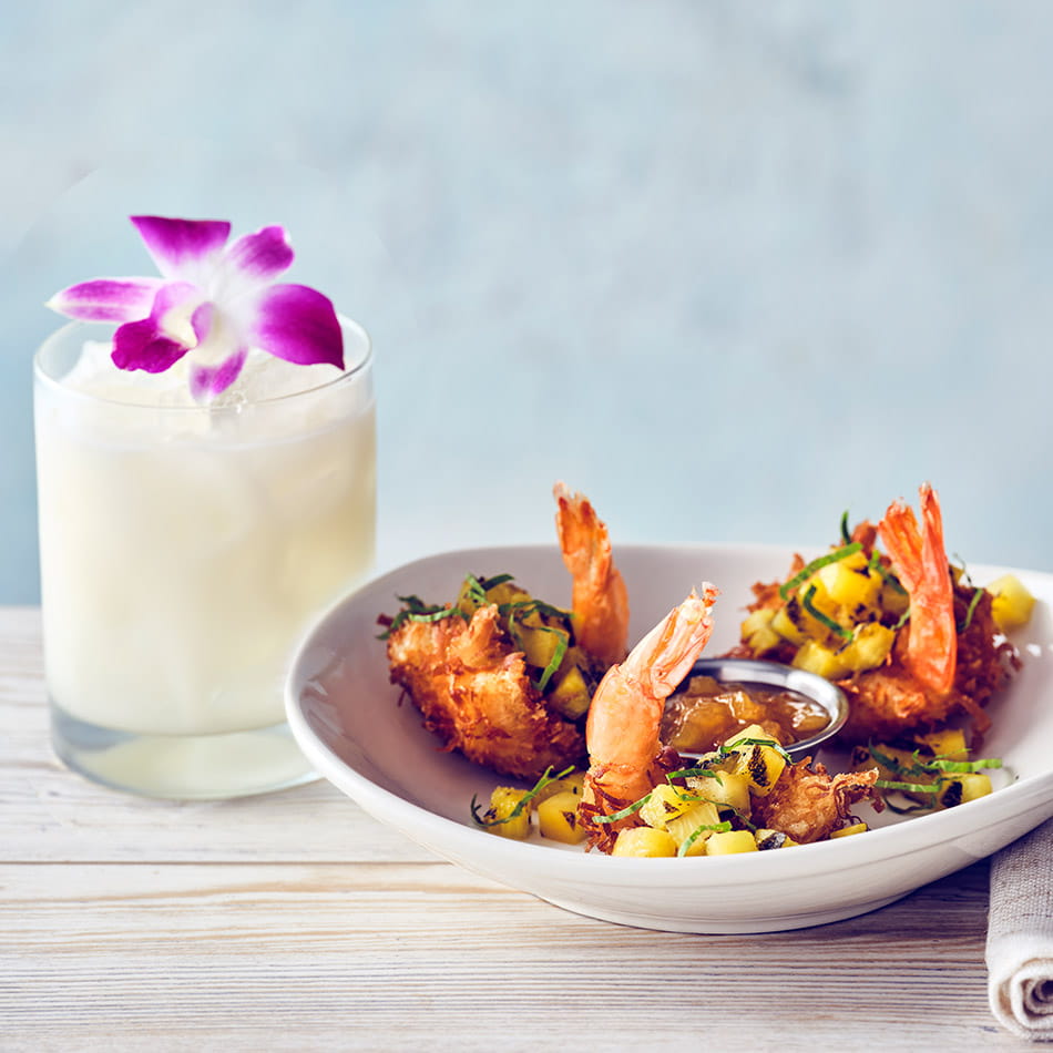 COURSE 1  COCONUT SHRIMP Crispy jumbo shrimp, topped with grilled pineapple and served with pineapple glaze for dipping.  ORCHID ISLE Inspired by Beachbum Berry’s tiki style, this cocktail is crafted with Bacardi rum, Domaine de Canton, lychee, and coconut. The lychee enhances the shrimp’s sweetness, while the coconut and ginger keep the pairing light and balanced.