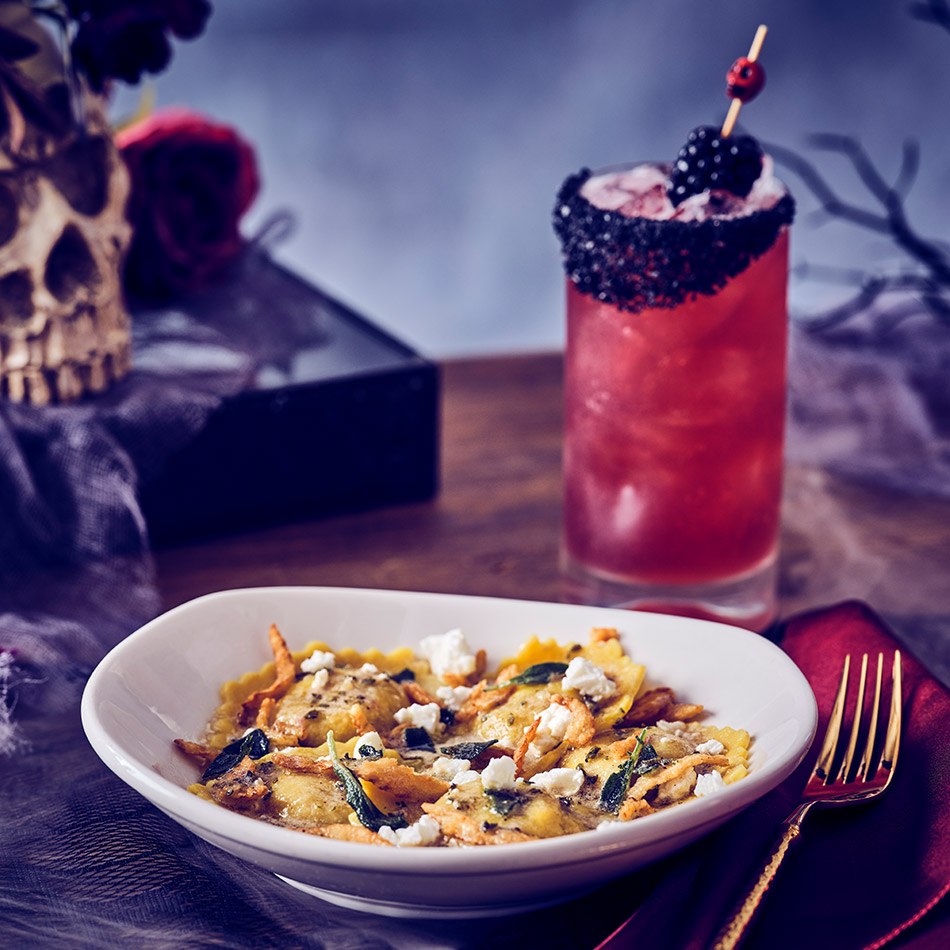 THE CONJURING PUMPKIN RAVIOLI No tricks, just treats. Pumpkin-stuffed ravioli topped with crispy onions, crumbled feta, crispy sage and a bewitchingly rich browned butter sauce. BLACK WIDOW A wickedly refreshing cocktail with Patrón Silver tequila, blackberry, lime and house-made sour mix, finished with an eerie black salt rim and a touch of sweet darkness. The blackberry and lime notes brighten the rich pumpkin ravioli, while the tequila complements the feta and nutty browned butter sauce.