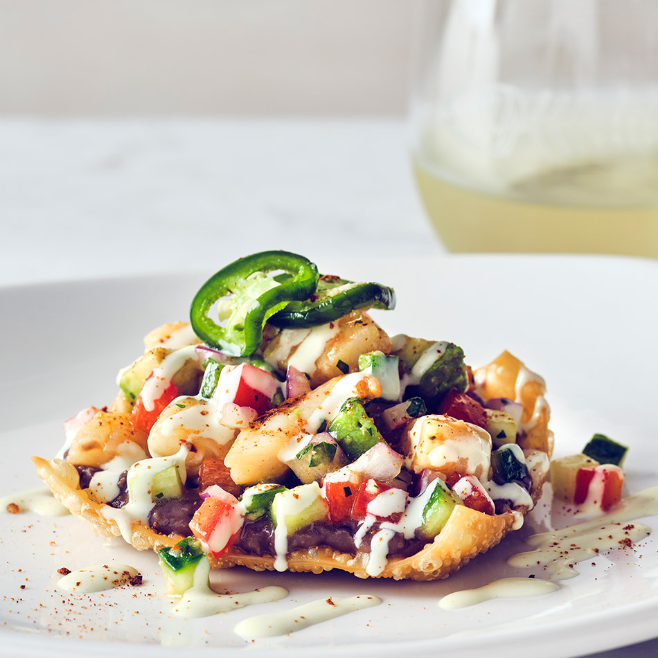 COURSE 1 ROASTED SHRIMP TOSTADA Savory roasted shrimp on a crispy tostada with black bean purée, pickled veggies, jalapeños, and diced avocado, drizzled with wasabi cream sauce. SANTA MARGHERITA PINOT GRIGIO This refreshing wine balances the bold flavors of the dish with its crisp acidity, clean finish, and subtle fruit notes, providing a perfect counterpoint to the dish’s spice and creaminess.