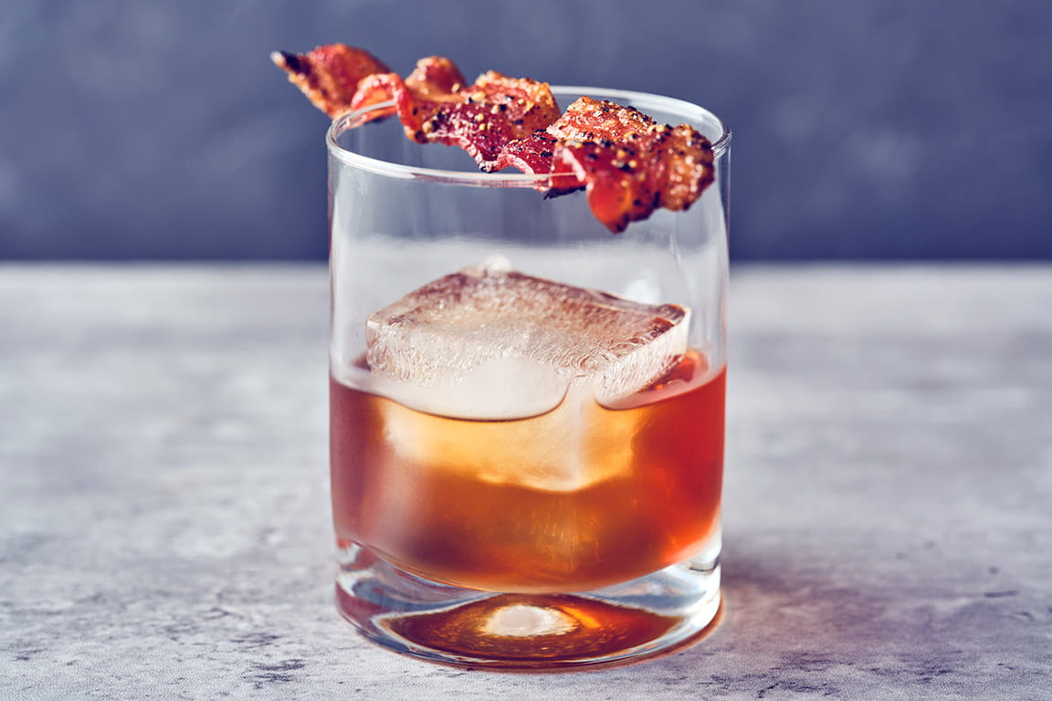 WHISTLEPIG MAPLE OLD FASHIONED WhistlePig PiggyBack bourbon, WhistlePig's own Vermont maple syrup, Angostura bitters and candied peppered bacon.
