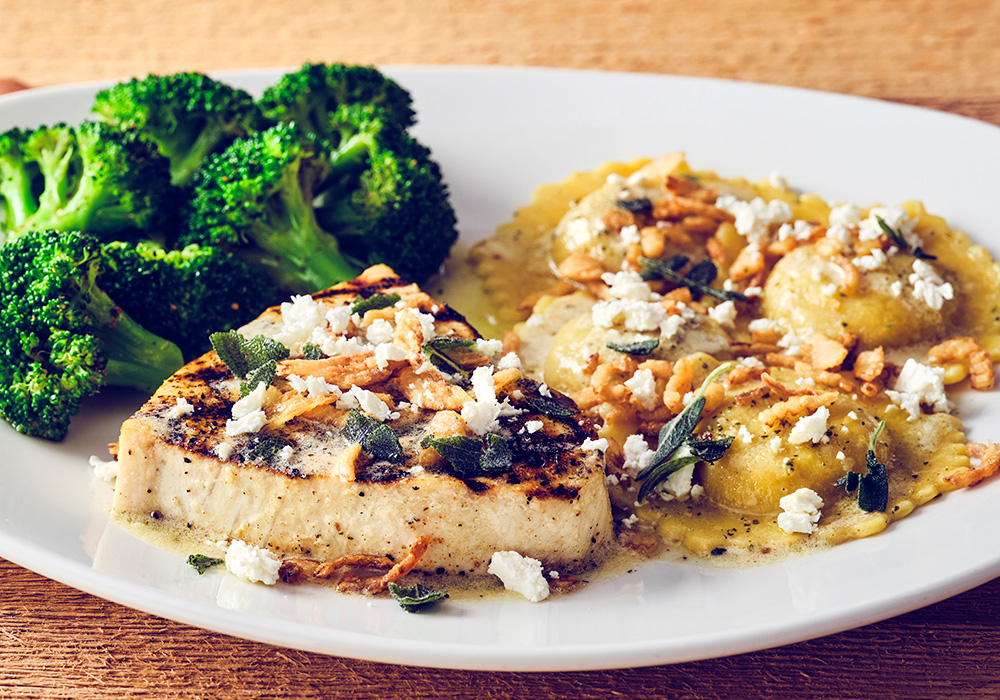 SWORDFISH & PUMPKIN RAVIOLIWood-grilled swordfish and pumpkin ravioli finished with browned butter sauce, crispy onions, crumbled feta and sage, served with seasonal vegetable.