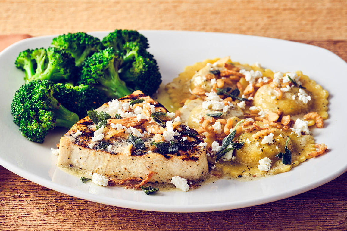 SWORDFISH & PUMPKIN RAVIOLIWood-grilled swordfish and pumpkin ravioli finished with browned butter sauce, crispy onions, crumbled feta and sage, served with seasonal vegetable.