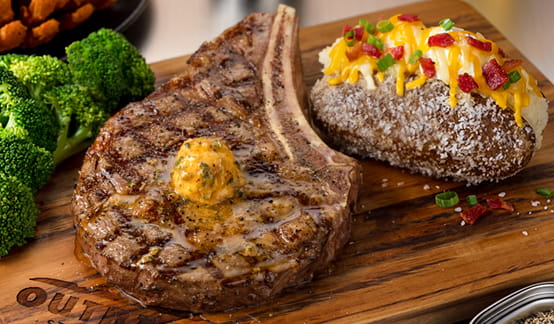 Bone-in Ribeye with Cowboy Butter, broccoli, loaded baked potato
