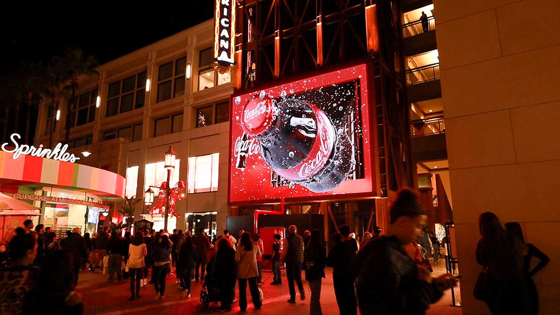 Nighttime shot of Coca-Cola campaign featuring Girl with a Pearl Earring at brand activation at The Americana at Brand
