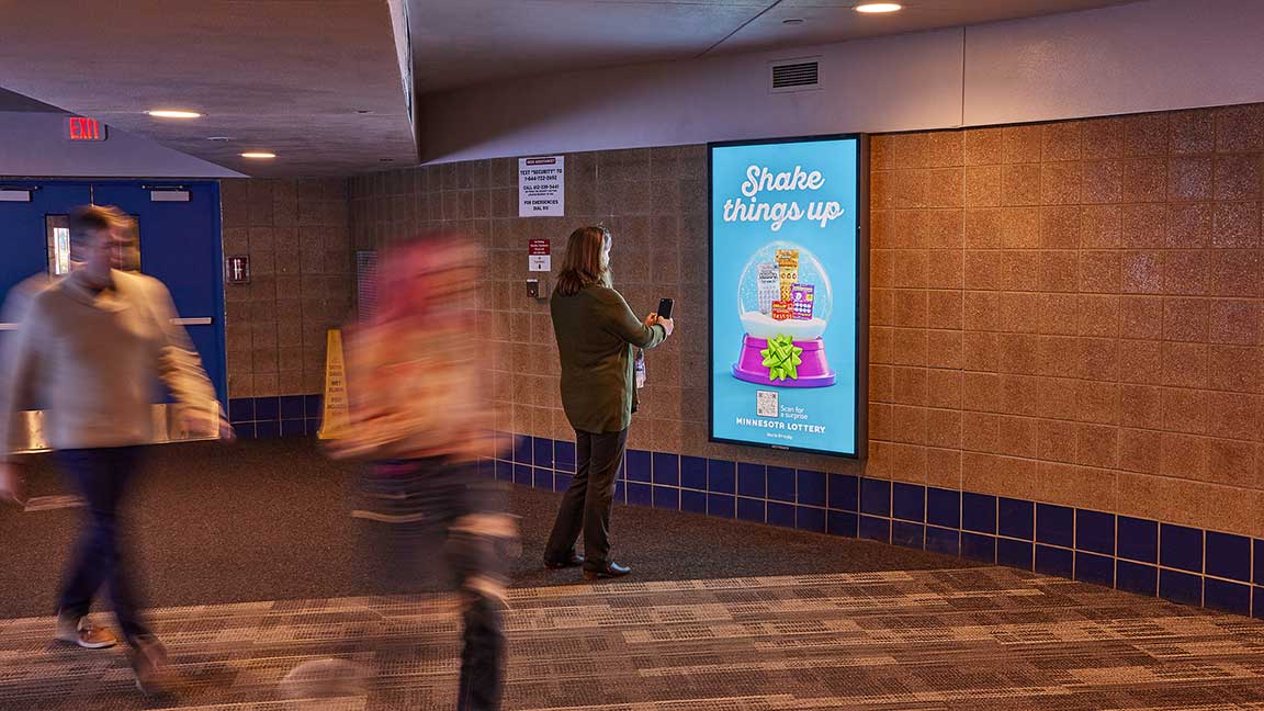 Person scanning QRad on Minnesota Lottery ad in Skyway