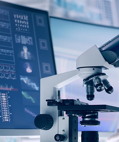 A microscope and computer monitor in a medical device lab