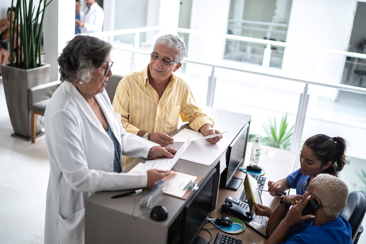 Middle-aged woman checking in at a doctor's office, demonstrating a seamless and welcoming healthcare experience.