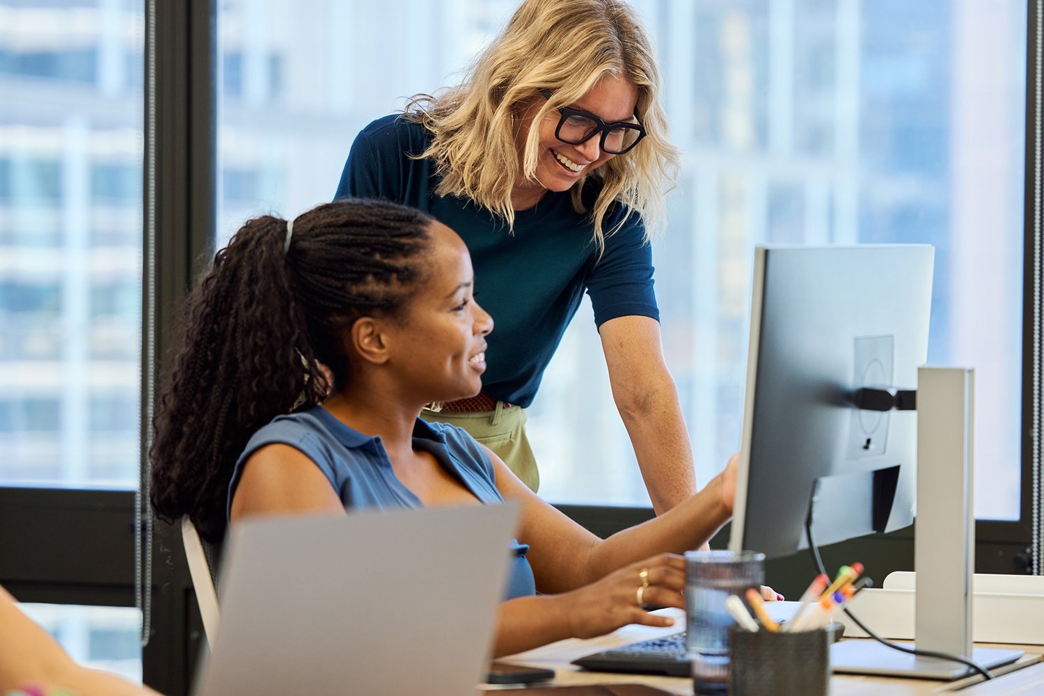 Two professionals collaborating together on a desktop