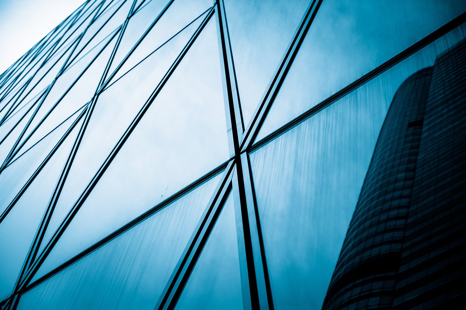 Majestic view looking up at a towering skyscraper against a clear sky, symbolizing ambition and innovation.