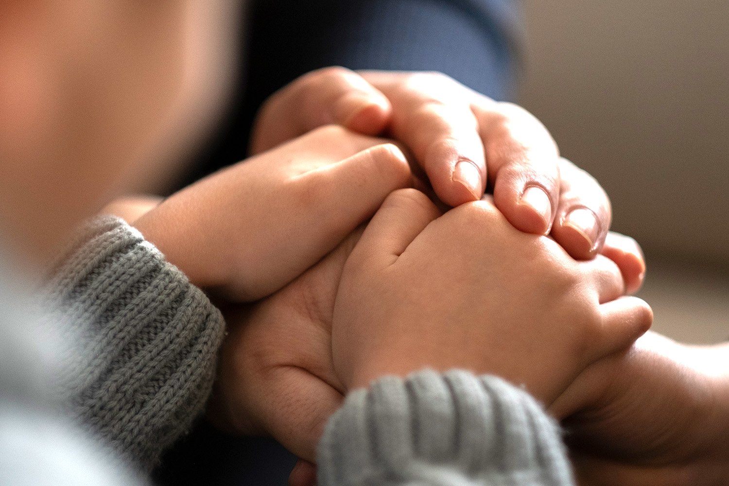 An image depicting a child and parent holding hands, symbolizing care and protection in the insurance industry.