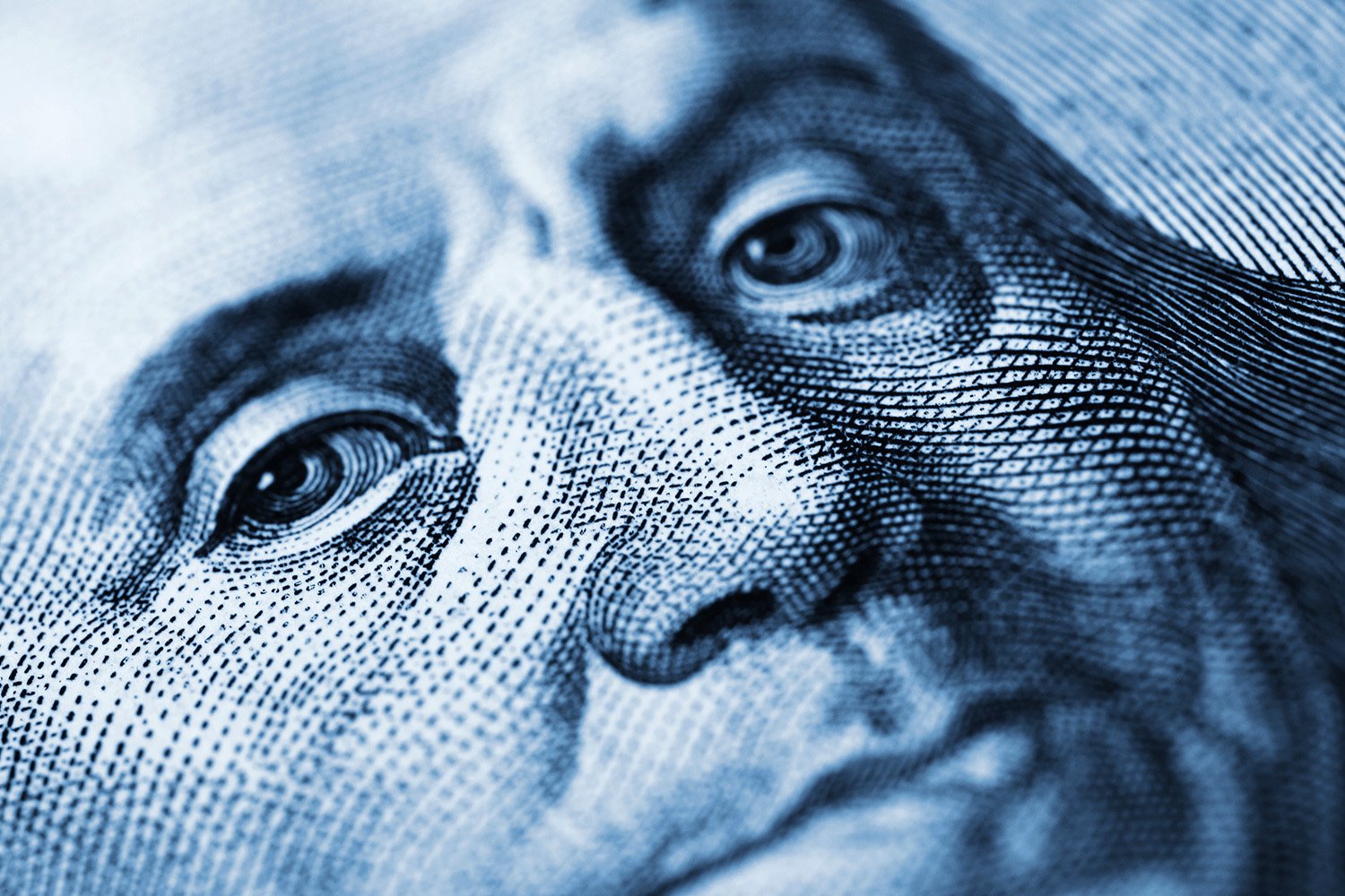 Close-up of Benjamin Franklin's face on a US bill highlighting intricate details and textures.