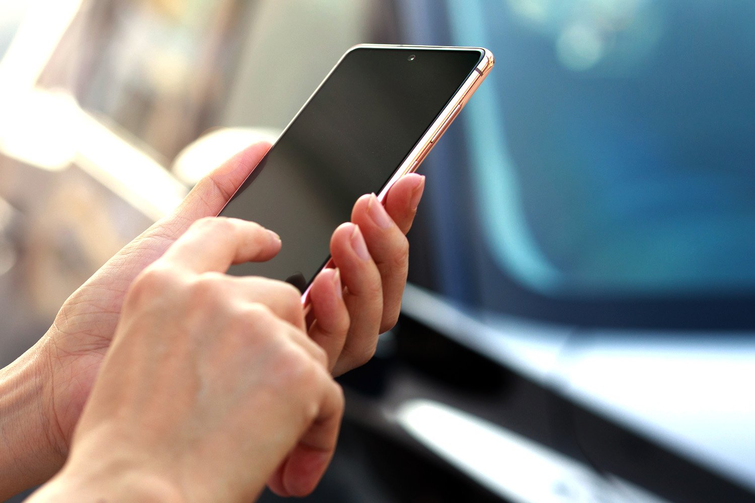 A hand holding a smartphone, illustrating mobile device usage.