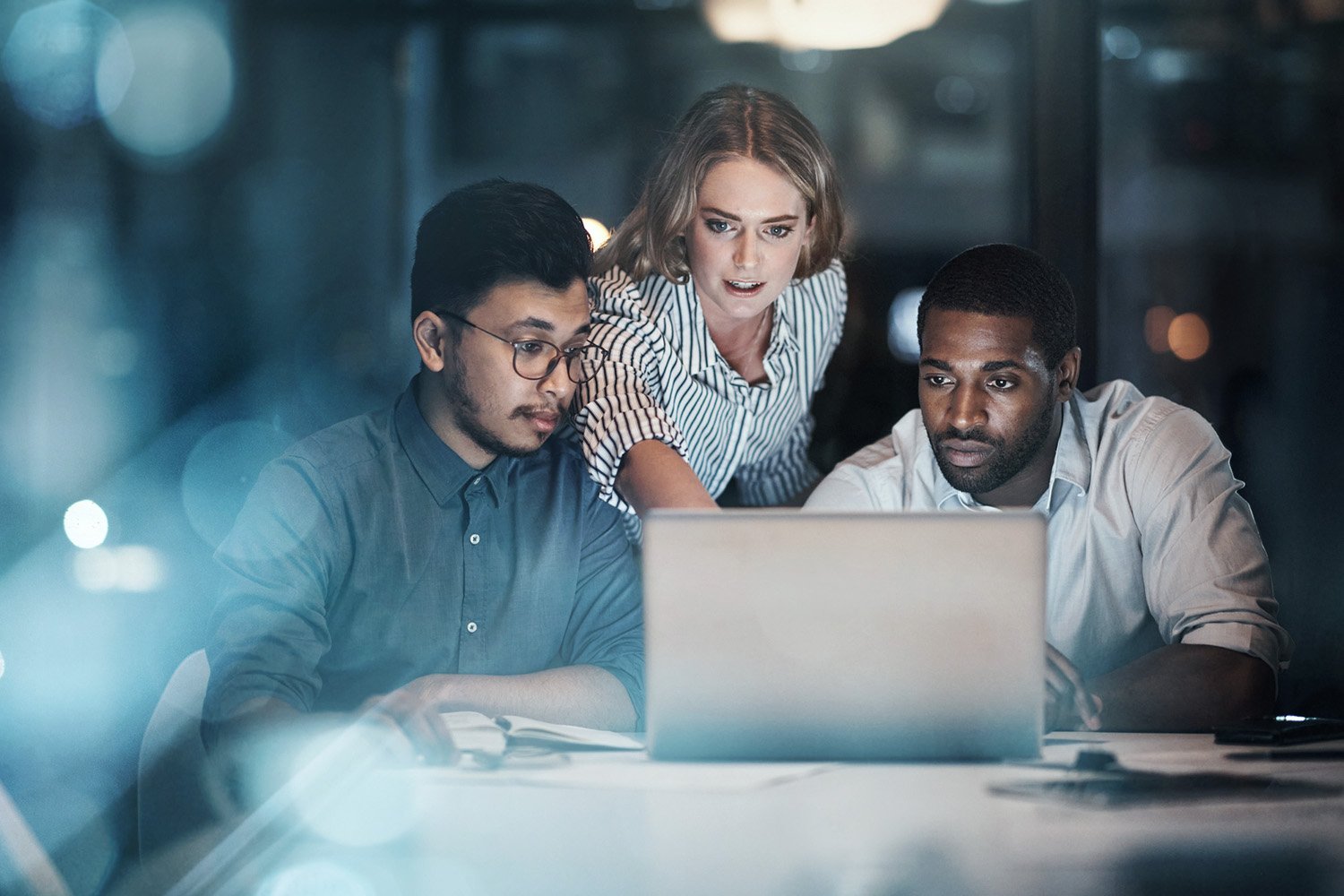 three colleagues working on laptop