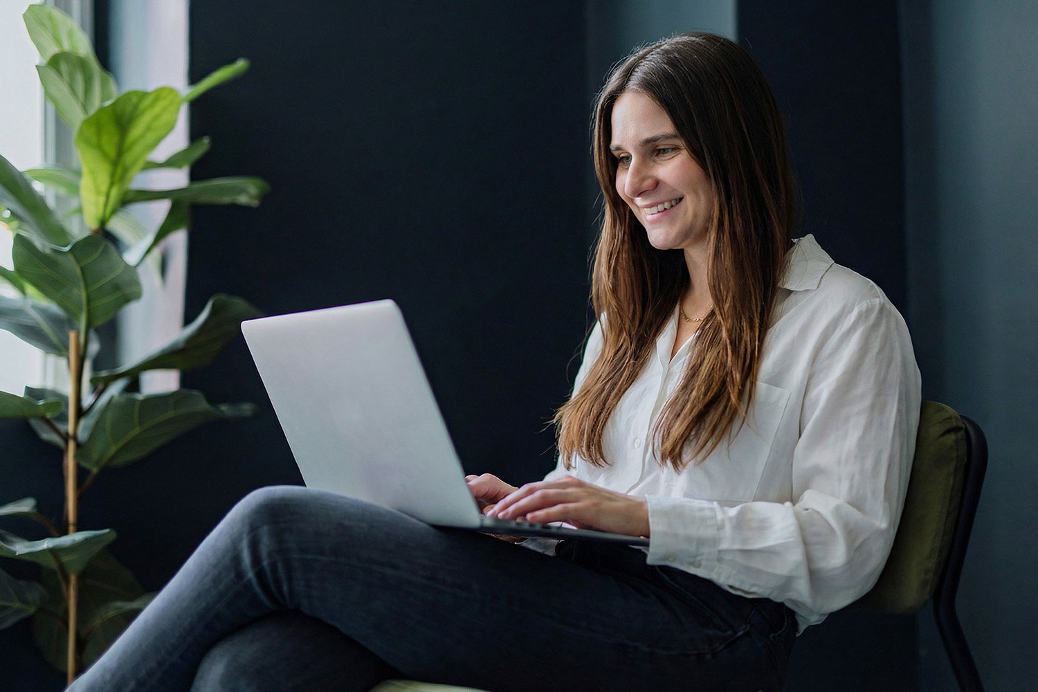 a happy employee working on a laptop