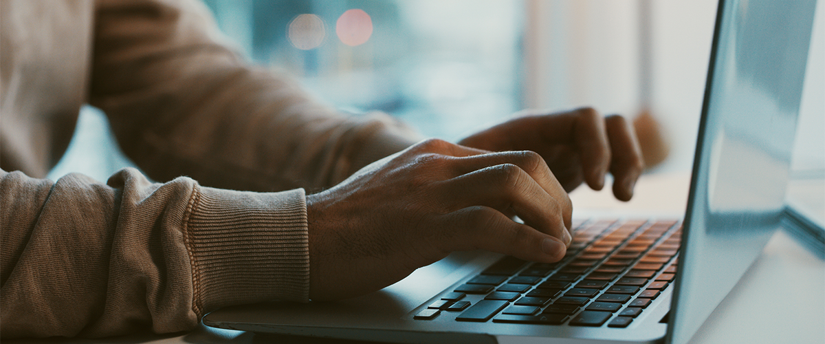 Person typing on laptop keyboard