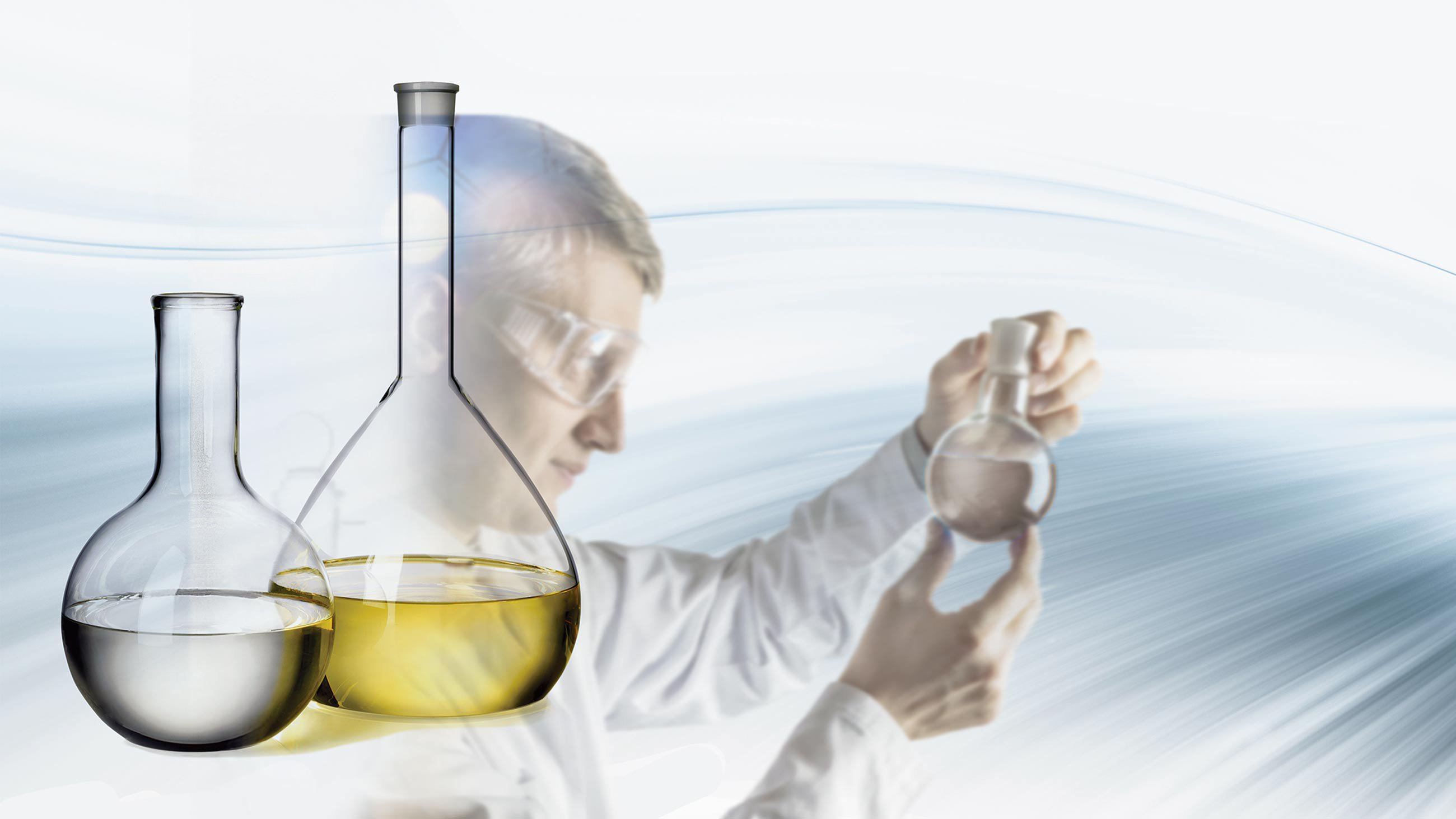 Scientist holding up a beaker of oil