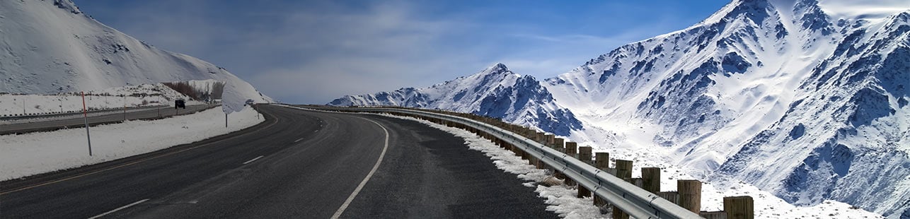 Road winding around snowy mountain