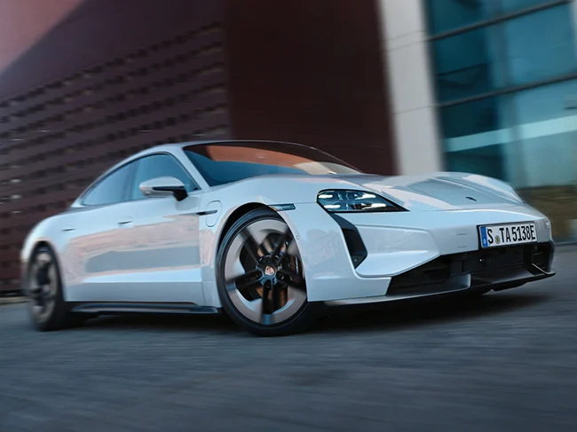 White Porsche Taycan in front of urban building