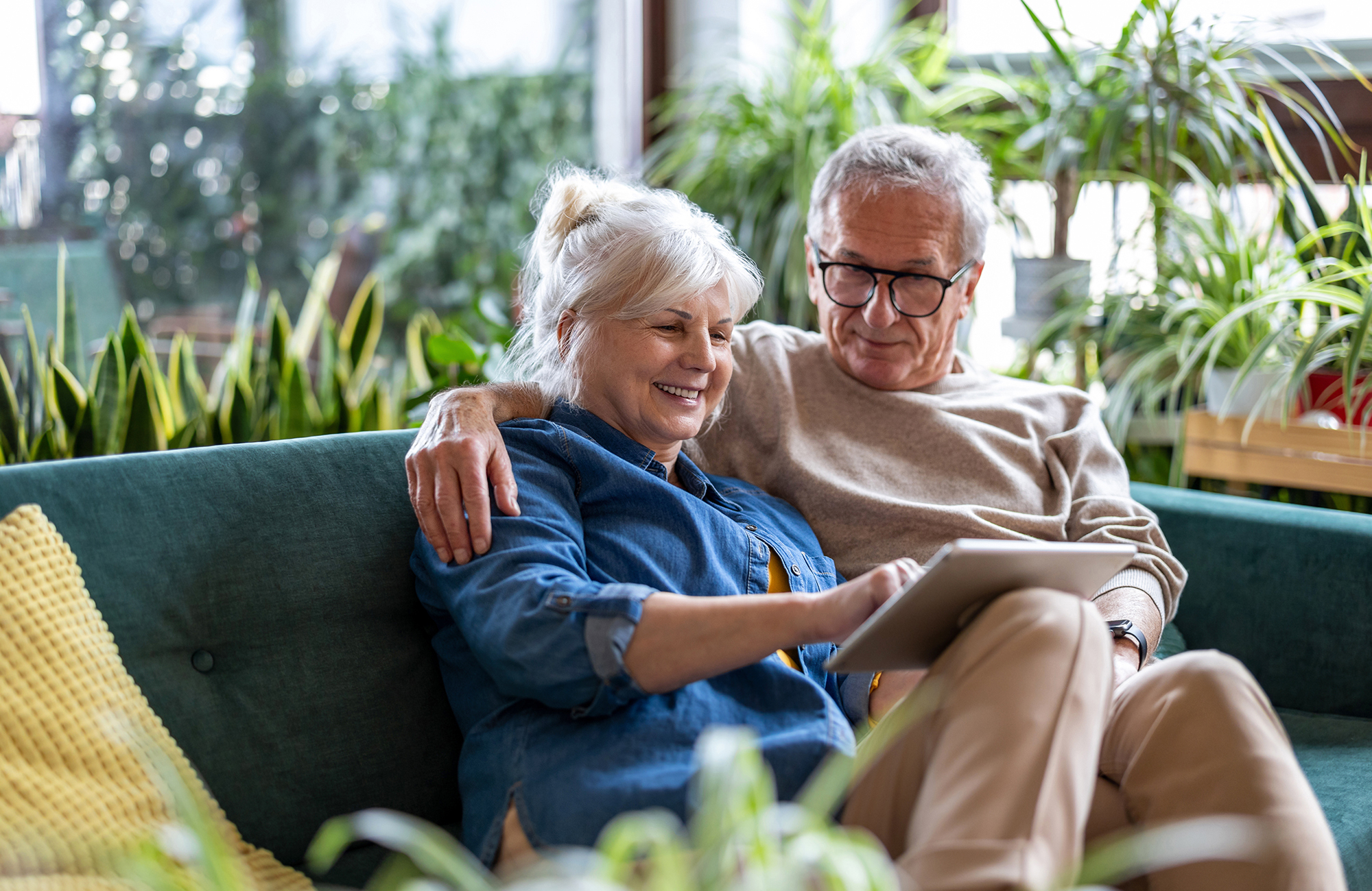Older couple with tablet on a couch
