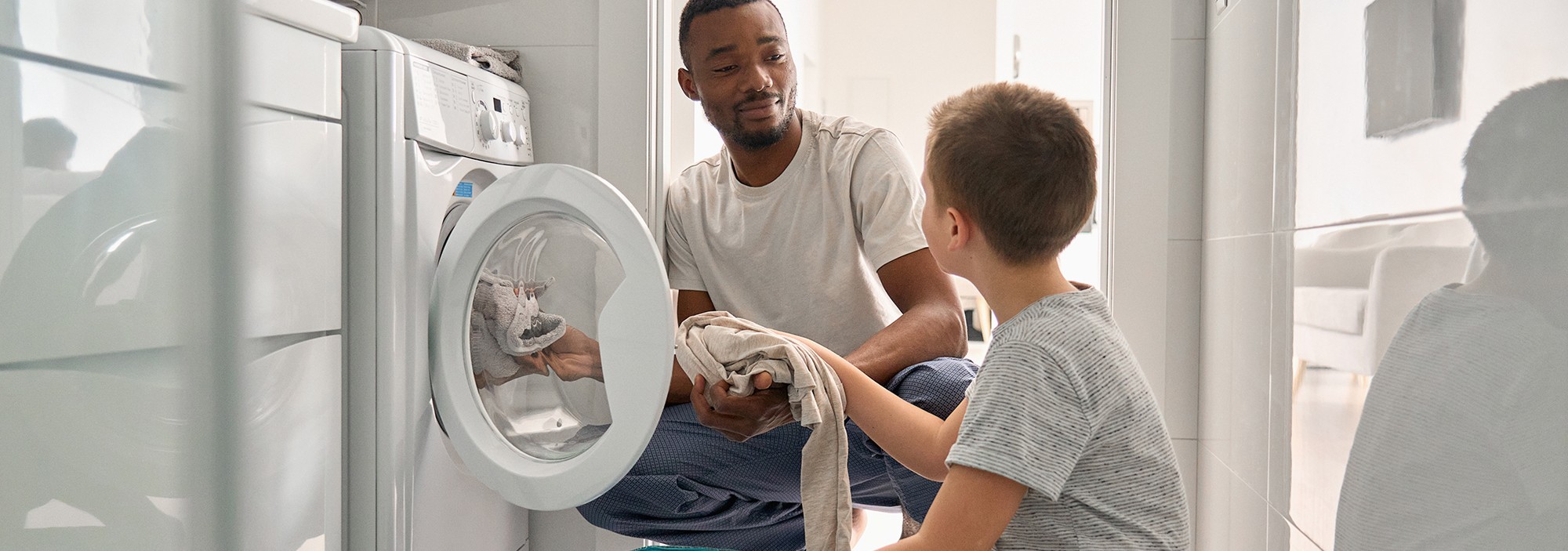Father and son loading laundry