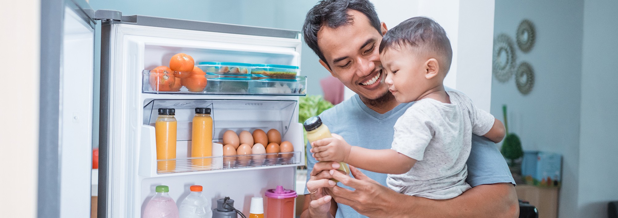 Man with a little kid in front of the fridge