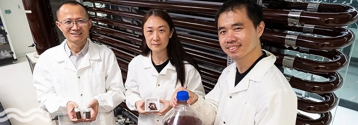 The NTU research team holding containers with sludge, and recovered resources
