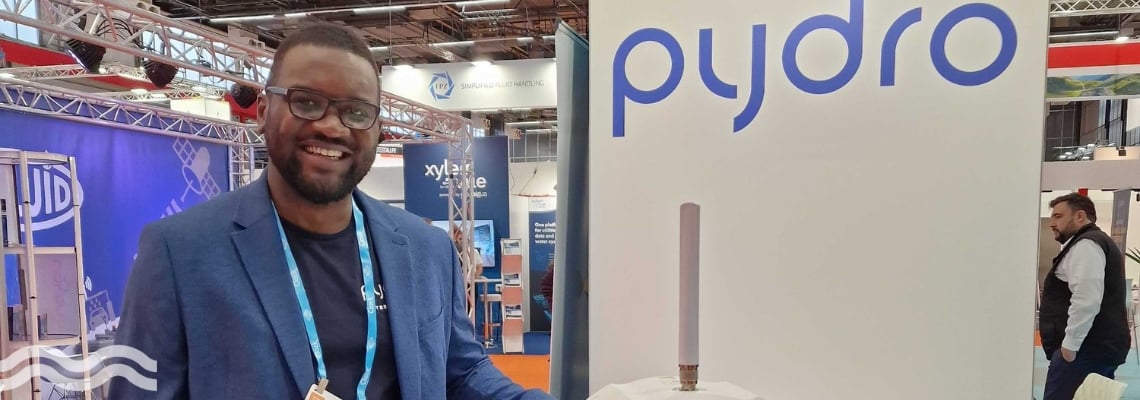 Pydro CEO and founder Mulundu Sichone standing next to a PT1 sensor