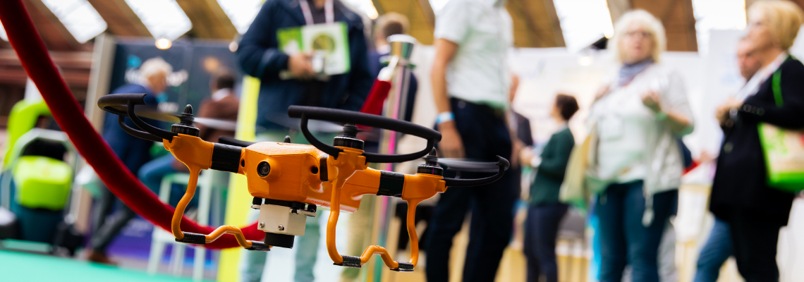 an orange drone with people in the background