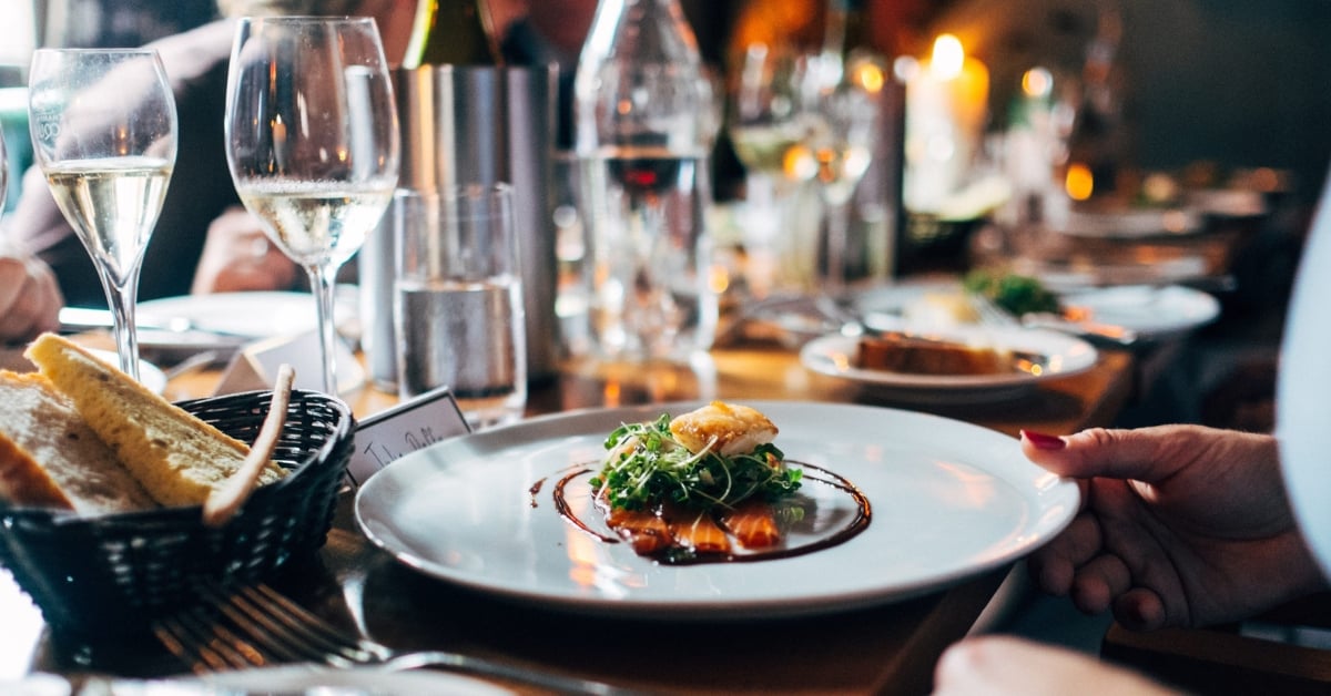 Diner met gerecht en wijnglazen in restaurantsetting