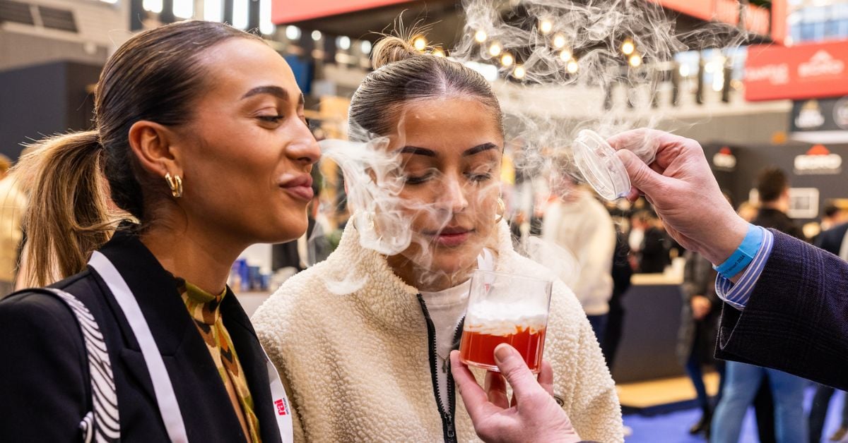 Twee vrouwen ruiken aan een drankje waar rook vanaf komt