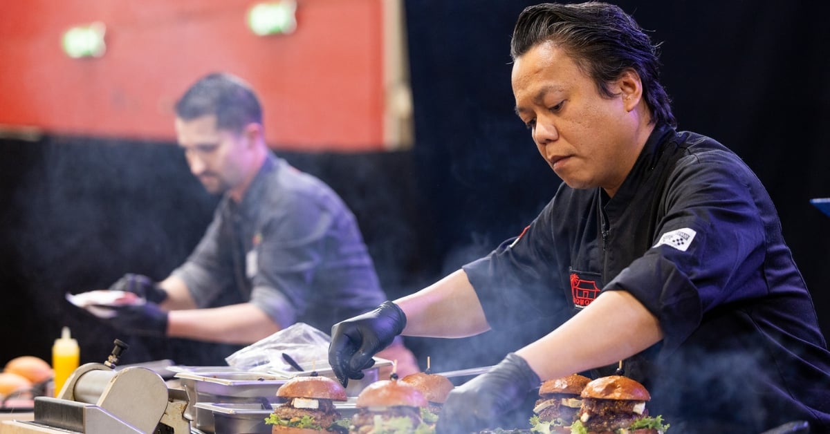 Twee chefs bereiden gourmetburgers tijdens een live kookdemonstratie op de beursvloer van Horecava